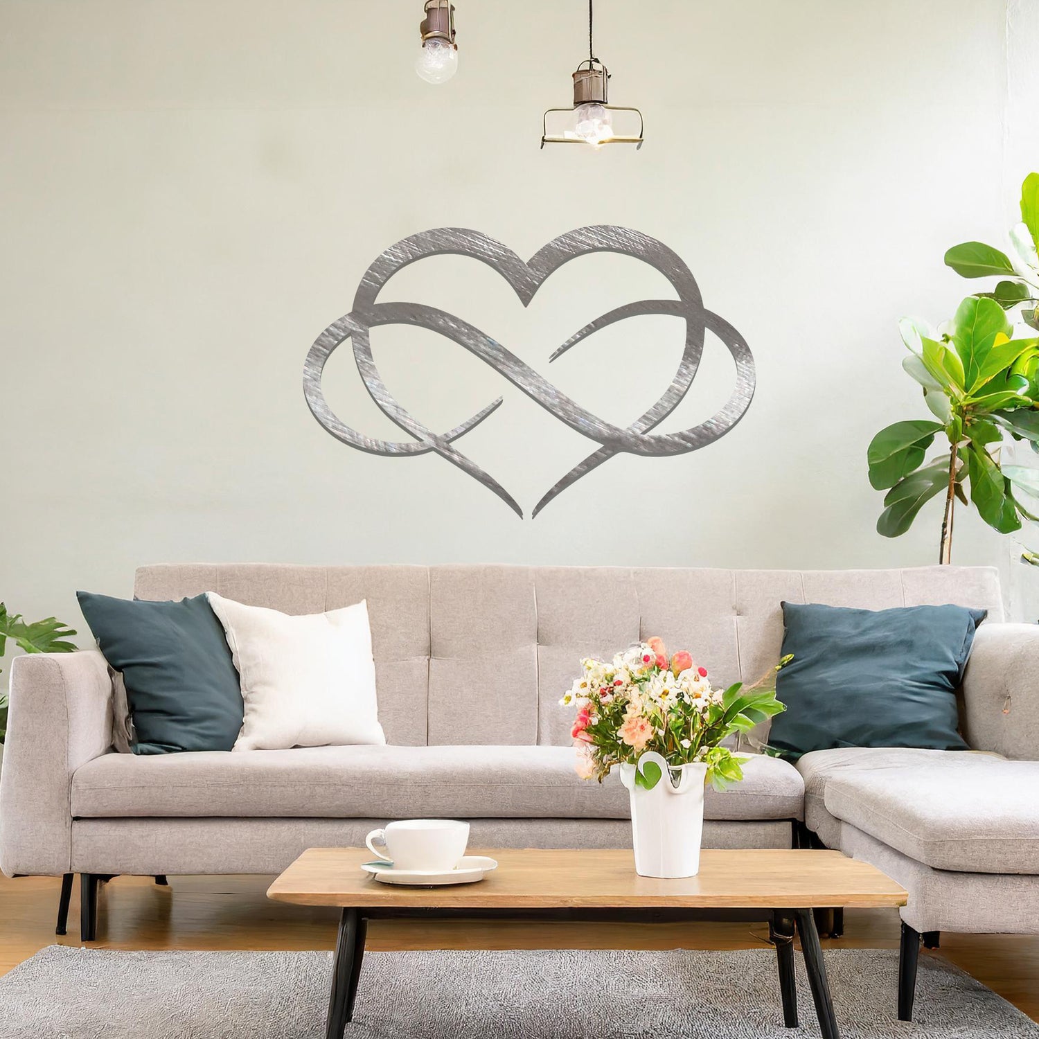 Metal infinity heart wall art with a sleek intertwined design, perfect for adding a modern touch to any room. Displayed on a neutral wall within a stylish living space for a contemporary decor statement.